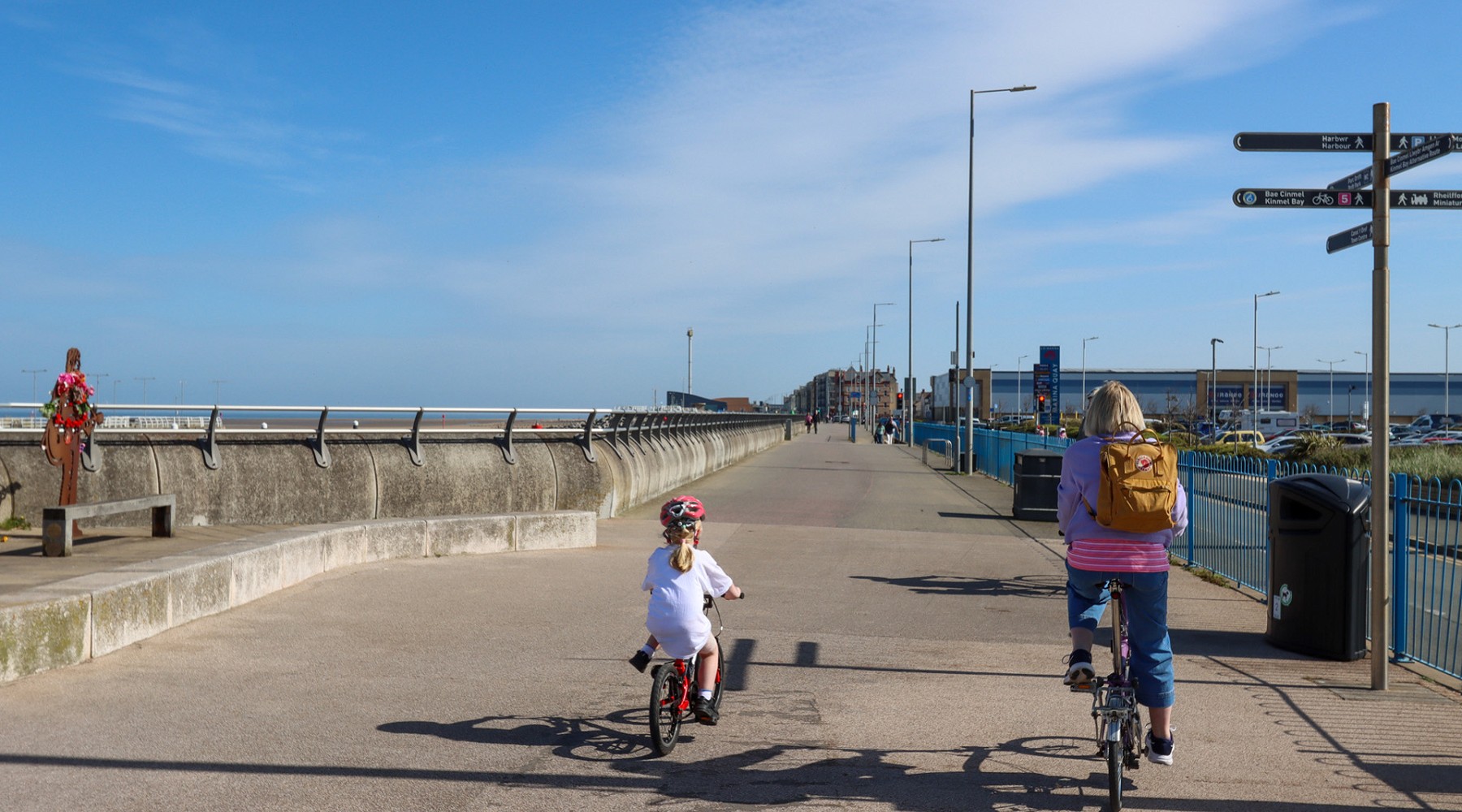 Two people riding bike along path in rhyl